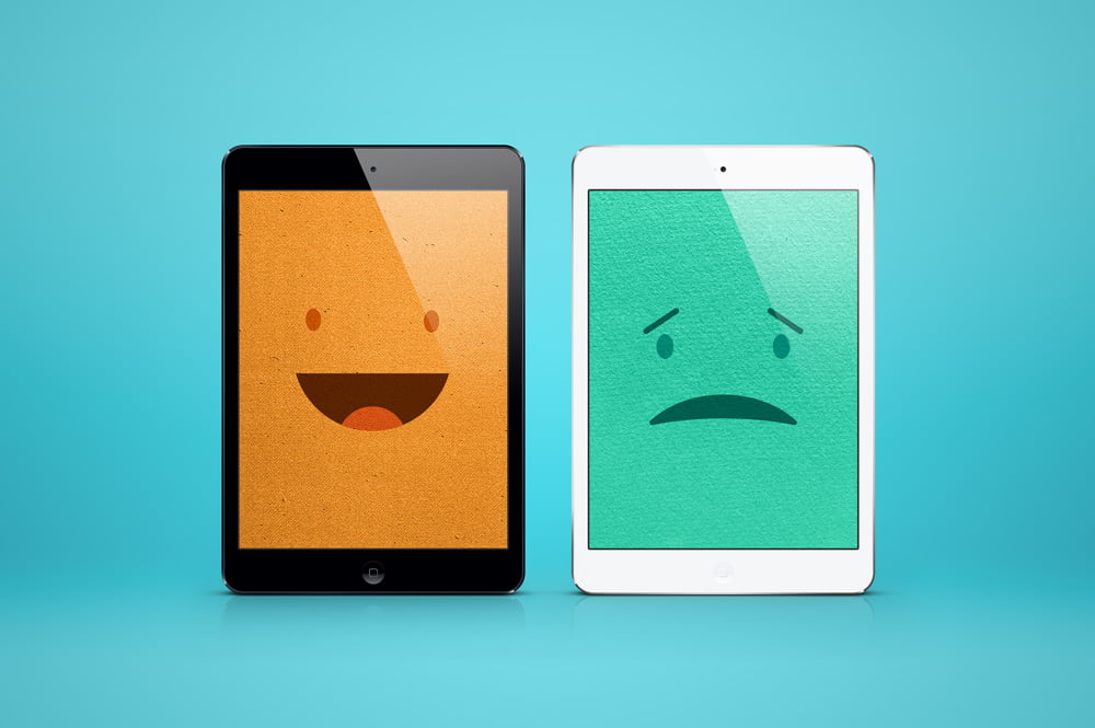 one ipad with smiling face and one with sad face